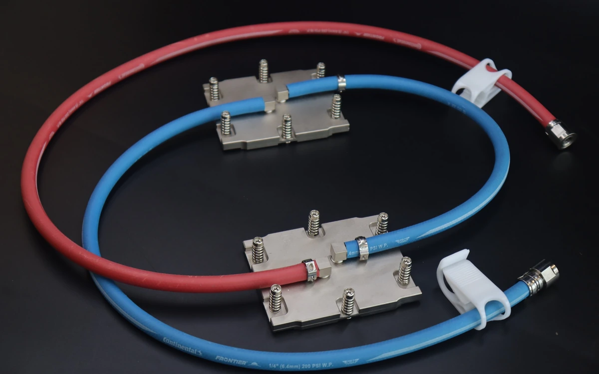 Dual CPU/GPU liquid cold plates with red and blue coolant hoses and quick-connects